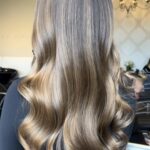 Bronde balayage hair colour — cool-toned, dimensional ribbons of light melting through a brunette base, styled into glossy waves at Matthew Jonathan Salon in Oakville.