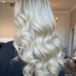 Long, luminous platinum blonde waves with soft dimensional highlights — a polished blonding result at Matthew Jonathan Salon in Oakville.